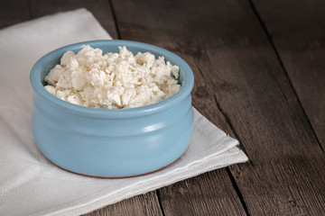cottage cheese, soft homemade, curd cheese, in a blue plate on a wooden background, fresh dairy products, natural taste