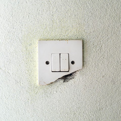 Old damage light switch on white wall