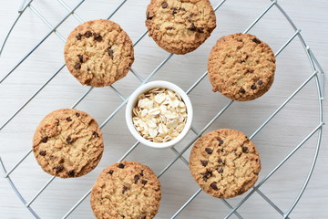 Oatmeal cookies and chocolate chips on light background