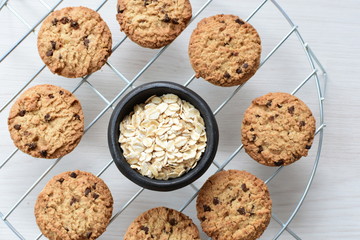 Oatmeal cookies and chocolate chips on light background