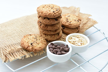 Oatmeal cookies and chocolate chips on light background