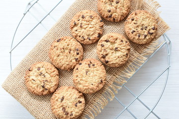 Oatmeal cookies and chocolate chips on light background