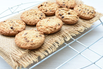 Oatmeal cookies and chocolate chips on light background