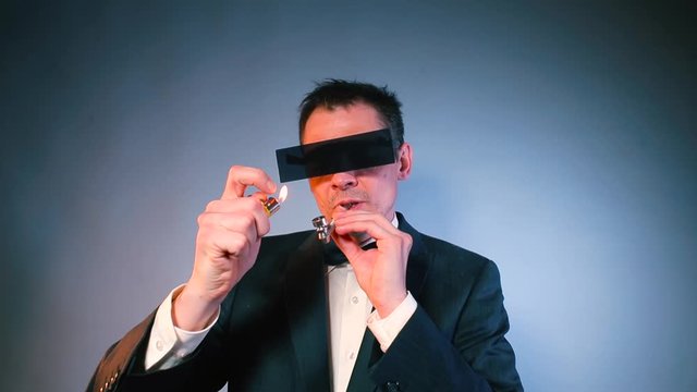 A businessman in black glasses smokes CBD cannabis through a pipe in office. Confident man takes off his glasses and looks at the camera. The concept of deviant behavior.