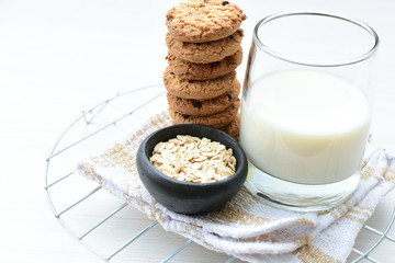 Oatmeal cookies and chocolate chips on light background