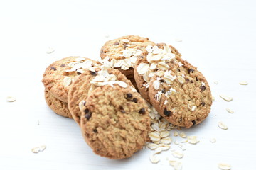 Oatmeal cookies and chocolate chips on light background
