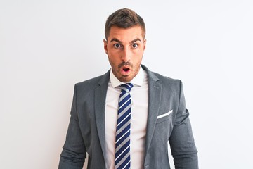 Young handsome business man wearing suit and tie over isolated background In shock face, looking skeptical and sarcastic, surprised with open mouth