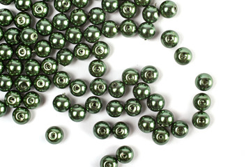 Large green beads are scattered on a white isolated background