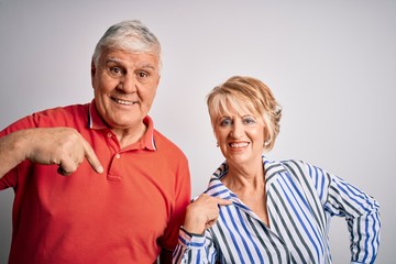 Senior beautiful couple standing together over isolated white background looking confident with smile on face, pointing oneself with fingers proud and happy.