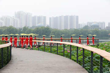 Women in red cheongsams are performing in a walk show, Luannan County, Hebei Province, China