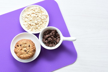 Oatmeal cookies and chocolate chips on colorful background