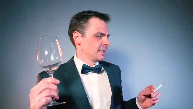 A man in a suit with a broken wine glass is looking for a waiter at a party. Awkwardness concept.