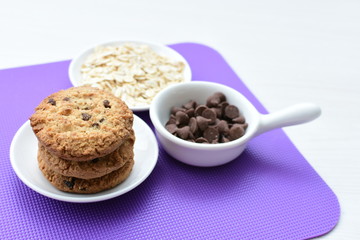 Oatmeal cookies and chocolate chips on colorful background