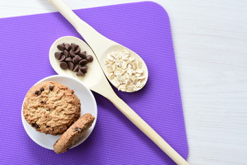 Oatmeal cookies and chocolate chips on colorful background