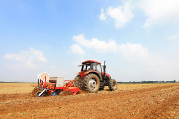 Farmers drive farm machinery to plant corn on the farm, Luannan County, Hebei Province, China.