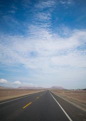 a lonely day road in the middle of the desert