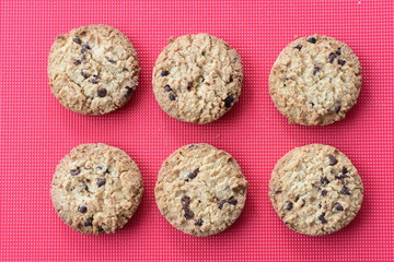 Oatmeal cookies and chocolate chips on colorful background