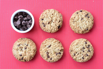 Oatmeal cookies and chocolate chips on colorful background