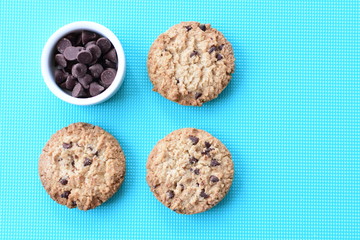 Oatmeal cookies and chocolate chips on colorful background
