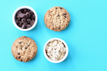Oatmeal cookies and chocolate chips on colorful background