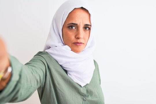 Young Arab Woman Wearing Hijab Taking Selfie Photo Over Isolated Background With A Confident Expression On Smart Face Thinking Serious