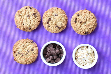 Oatmeal cookies and chocolate chips on colorful background