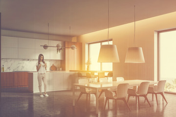 Woman in luxury white and wooden kitchen