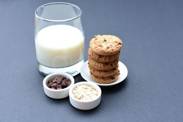 Oatmeal cookies and chocolate chips on black background