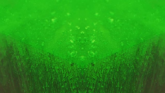 Paint drop texture. Toxic cascade. Neon green glitter fluid drip motion over cube angle.