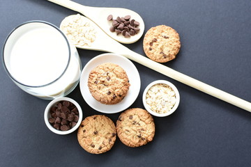 Oatmeal cookies and chocolate chips on black background