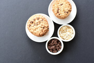 Oatmeal cookies and chocolate chips on black background