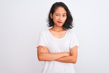 Young chinese woman wearing casual t-shirt standing over isolated white background skeptic and nervous, disapproving expression on face with crossed arms. Negative person.