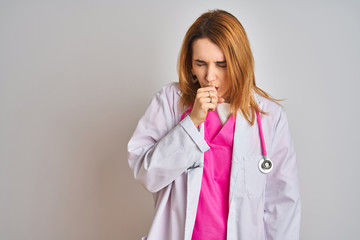 Redhead caucasian doctor woman wearing pink stethoscope over isolated background feeling unwell and coughing as symptom for cold or bronchitis. Healthcare concept.