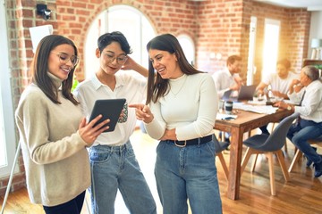 Business workers smiling happy. Standing with smile on face working together using tablet at the office