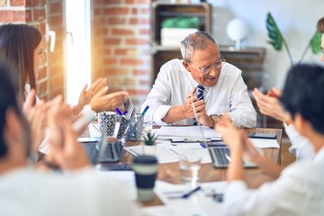 Group of business workers smiling happy and confident. Working together with smile on face applauding one of them at the office