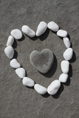 white stones around black stone in shape of heart