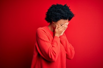 Fototapeta na wymiar Young beautiful African American afro woman with curly hair wearing casual sweater with sad expression covering face with hands while crying. Depression concept.