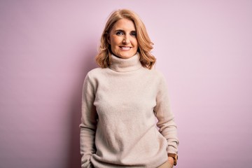 Obraz premium Middle age beautiful blonde woman wearing casual turtleneck sweater over pink background with a happy and cool smile on face. Lucky person.