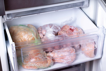 Plastic bags with frozen meat in refrigerator