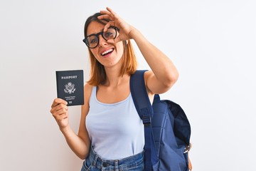 Beautiful redhead student woman wearing backpack and holding passport of united states with happy face smiling doing ok sign with hand on eye looking through fingers