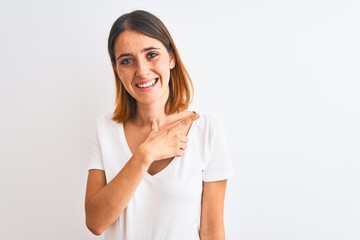 Beautiful redhead woman wearing casual white t-shirt over isolated background cheerful with a smile of face pointing with hand and finger up to the side with happy and natural expression on face
