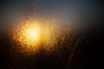 Cloudy glass in warm and cold colors. Dawn behind a blurry transparent surface. Abstract warm...