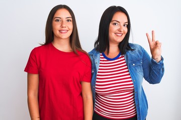 Young beautiful women wearing casual clothes standing over isolated white background showing and pointing up with fingers number two while smiling confident and happy.