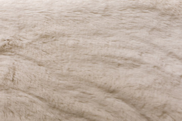 Background from artificial fur fabric with a low pile of light beige shade. Eco-friendly replacement for sodium fur