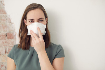 Woman wearing a mask to protect her from pandemic corona virus covid-19 influenza with copyspace