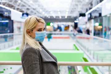 a young woman wears a protective mask while shopping at the Mall. the concept of disease health and virus protection.
