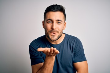 Young handsome man wearing casual t-shirt standing over isolated white background looking at the...