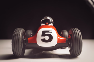 Red old racing car with number five painted on it