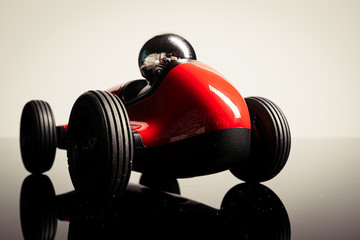 Fototapeta na wymiar Red vintage racing tiny car backwards on a studio shot