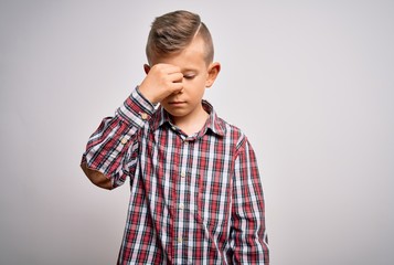 Young little caucasian kid with blue eyes wearing elegant shirt standing over isolated background tired rubbing nose and eyes feeling fatigue and headache. Stress and frustration concept.